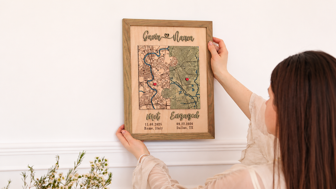 Woman hanging a personalized wooden engagement map showing where a couple met in Rome and got engaged in Dallas.