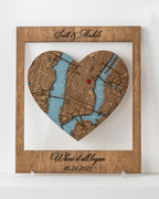 Heart-shaped wooden map cutout with engraved names and date on a white background