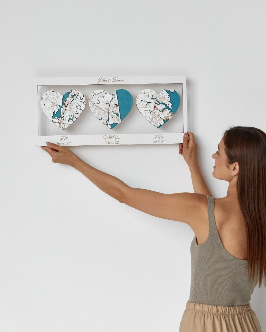 Woman holding a decorative wall art with heart-shaped designs against a white wall