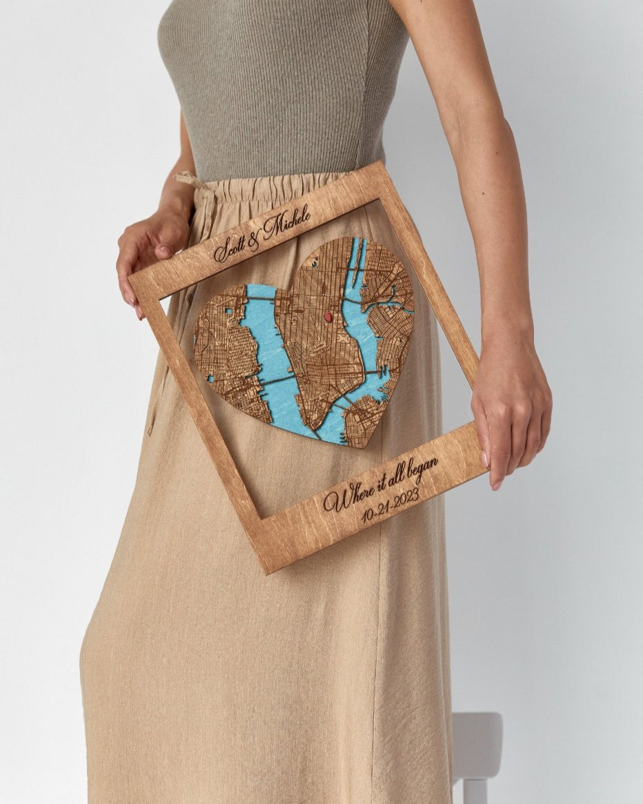 Person holding a wooden plaque with a map design on a plain background