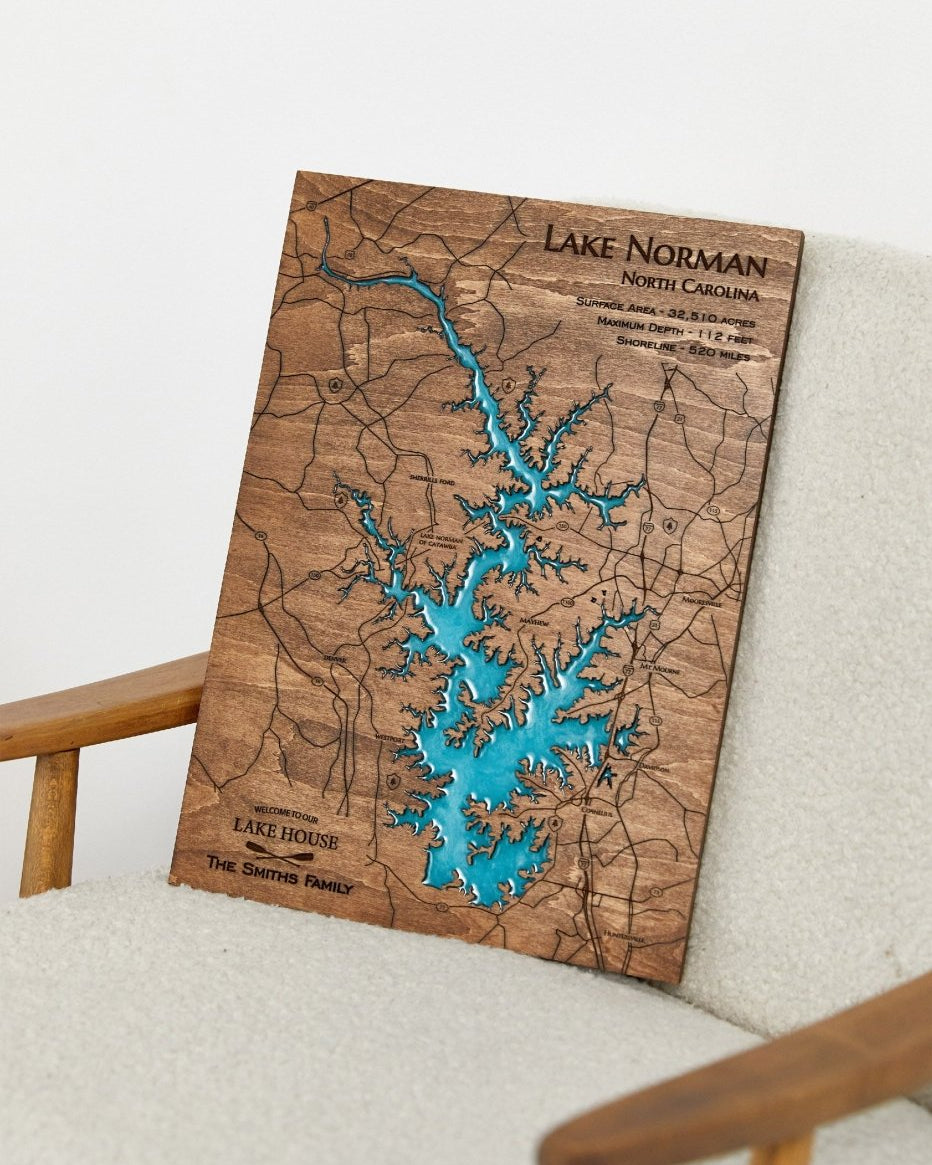 Wooden map of Lake Norman, North Carolina, on a white surface with a wooden frame.