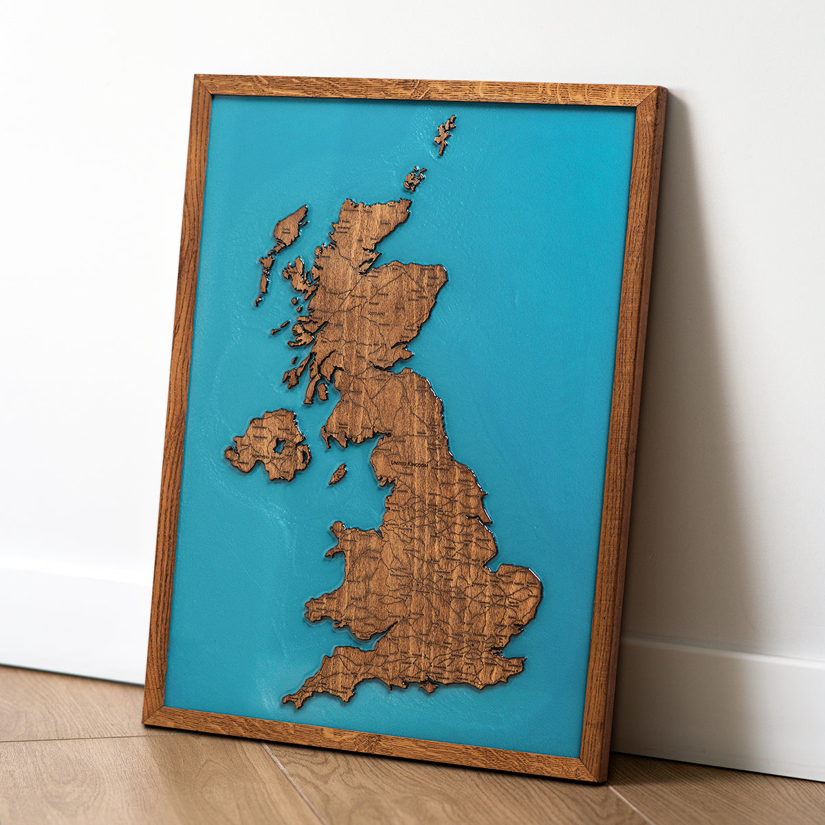 Solid natural oak frame detail on wooden United Kingdom map
