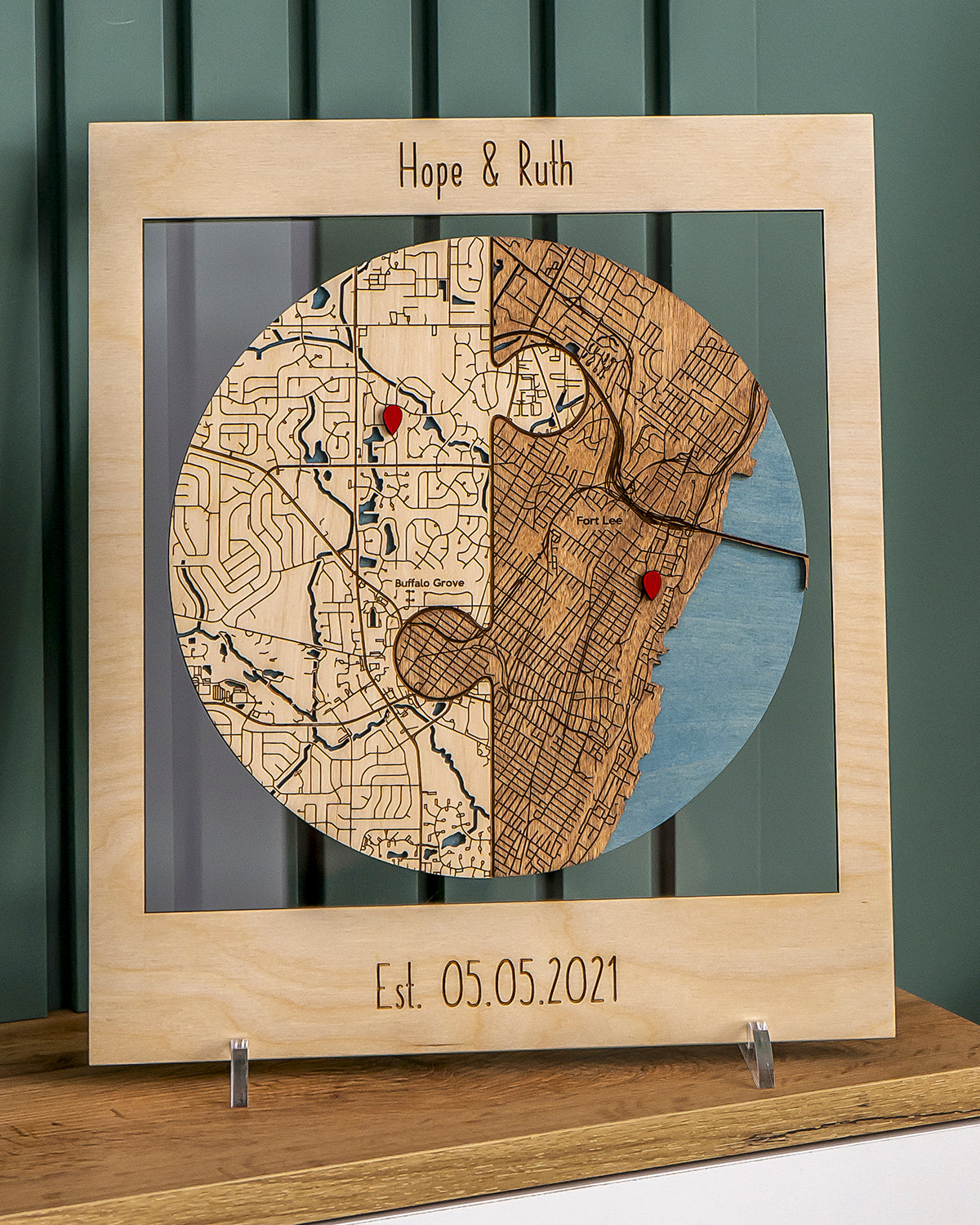 Wooden map with engraved names 'Hope & Ruth' and date 'Est. 05.05.2021' on a wooden stand.