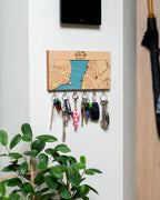 Key holder with keys attached to a wall next to a plant