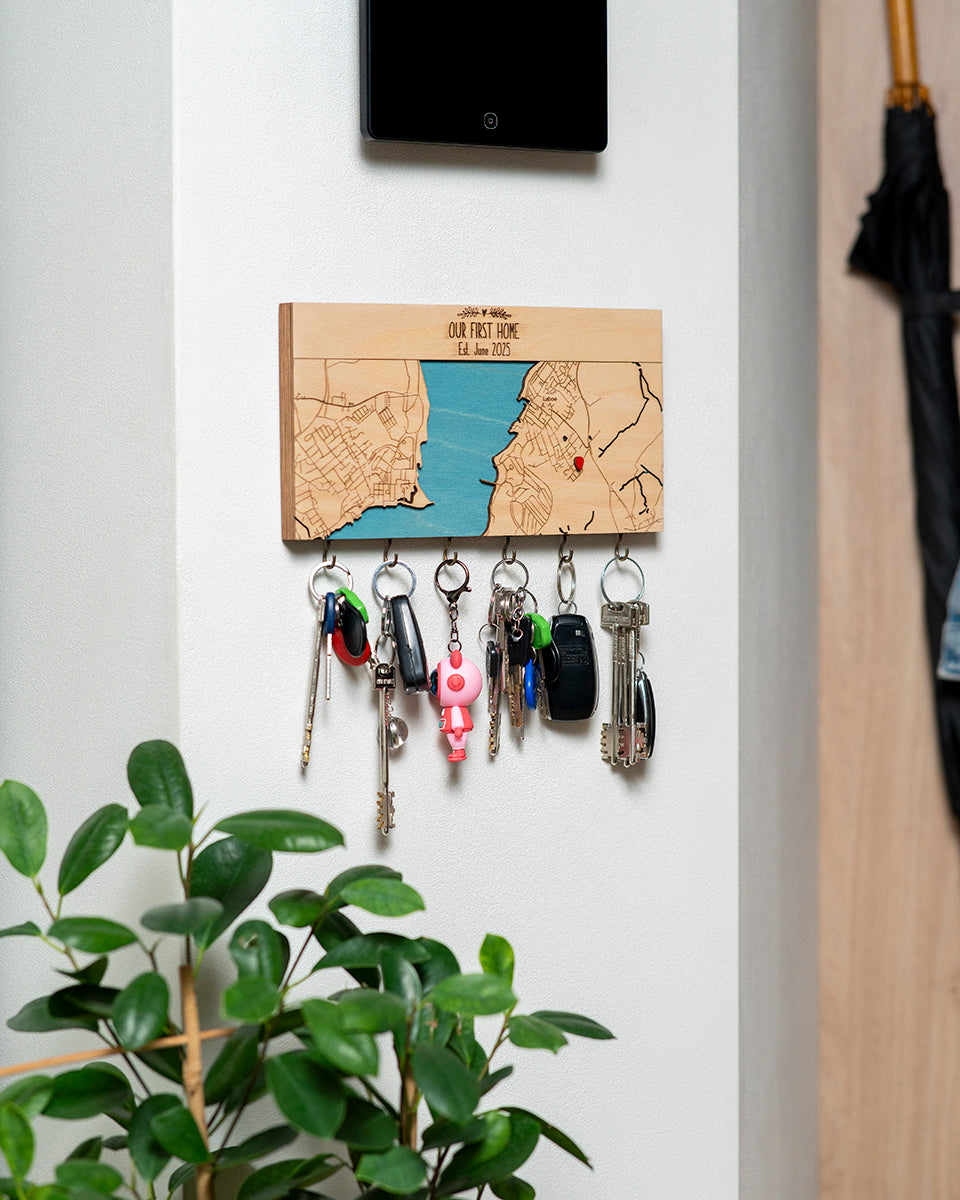 Key holder with keys attached to a wall next to a plant