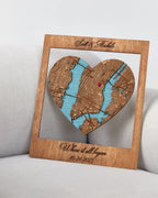 Wooden heart-shaped map cutout with engraved text on a light gray background