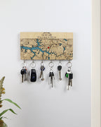Key holder with keys attached to a map background on a white wall.