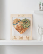 Heart-shaped map in a wooden frame with engraved dates on a white shelf.