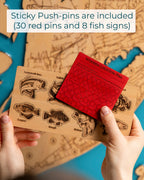 Red push-pin and wooden card with fish illustrations on a map background