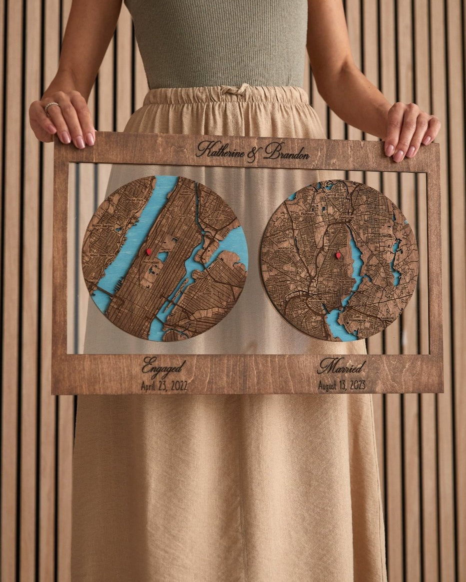 Person holding a wooden frame with two circular wooden maps engraved on it.