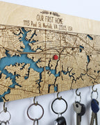 Wooden key holder with engraved map and 'Our First Home' text, featuring a red dot.