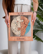 Person holding a wooden framed map with 'Hope & Ruth' and 'Est. 03.05.2021' text.