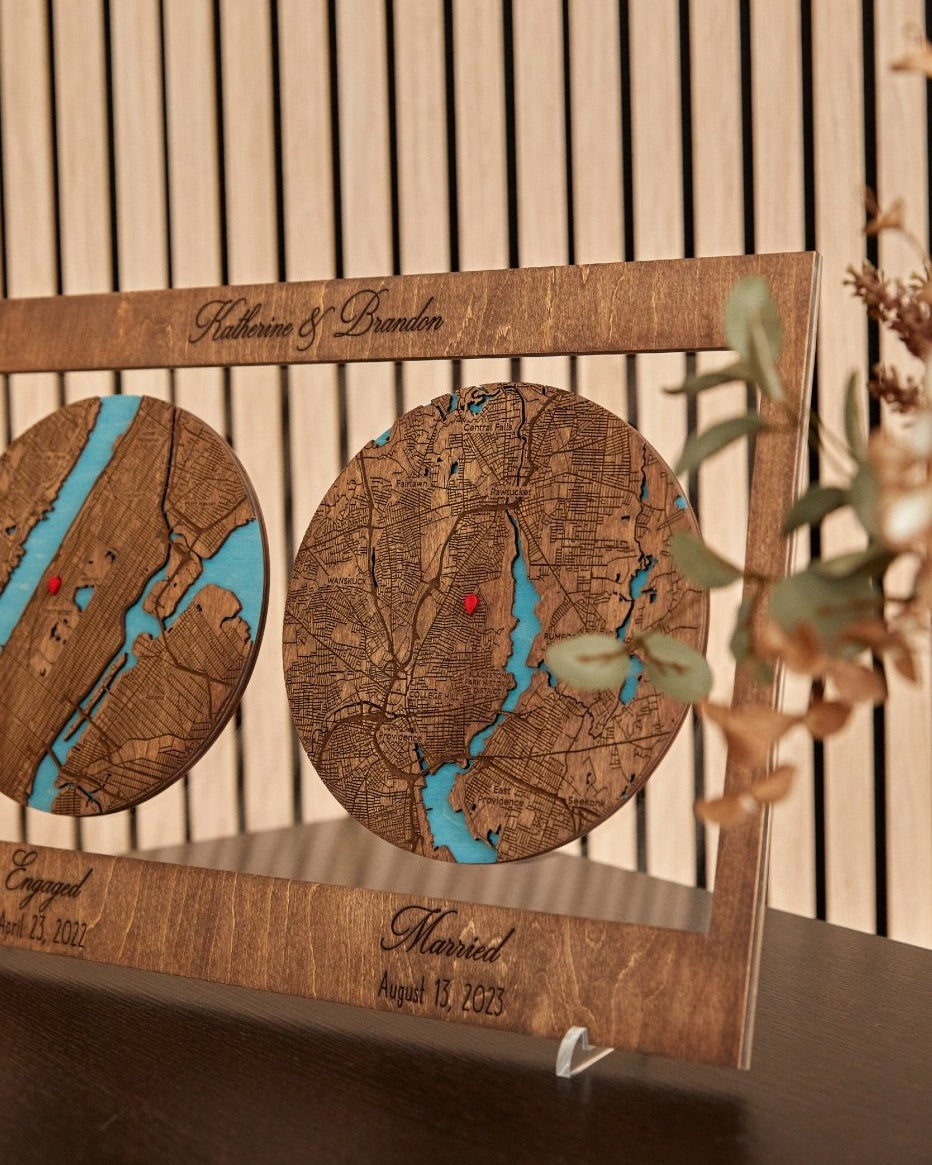 Wooden map decor with engraved text on a stand, featuring two circular maps with blue and red markers.
