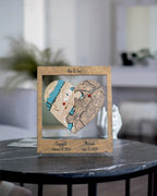 Wooden heart-shaped plaque with engraved map design on a round table.
