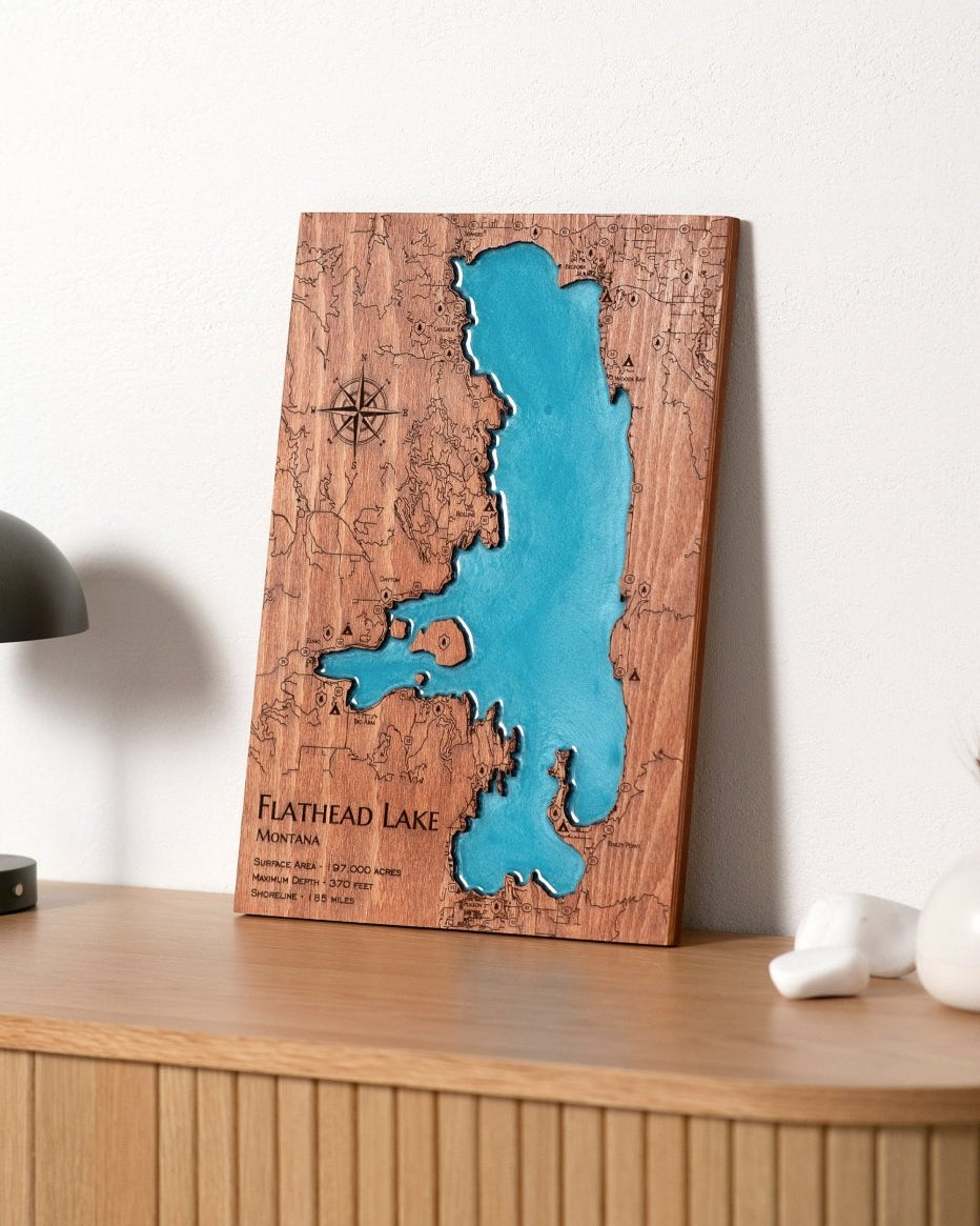 Wooden wall art of Flathead Lake with a blue water section on a wooden shelf.