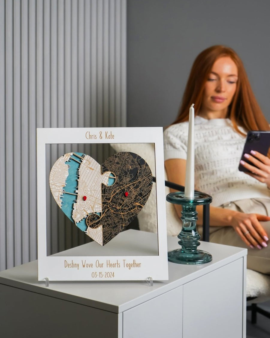 Heart-shaped decorative piece with personalized text on a table, woman using phone in the background