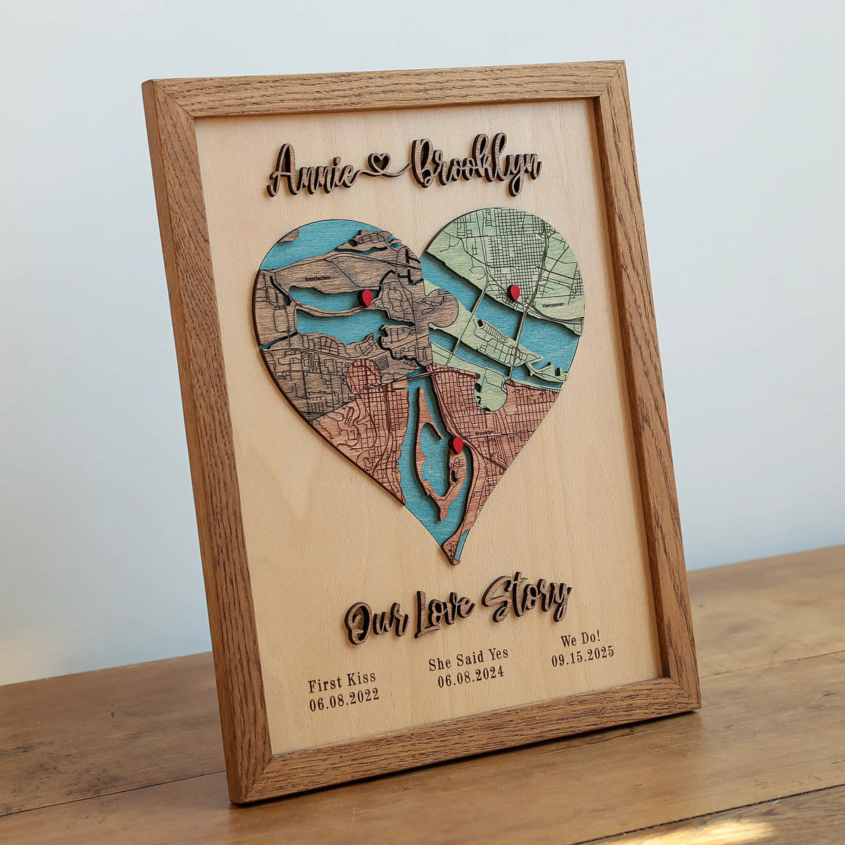 Three-location wooden heart map in an Early American oak frame with raised names and Our Love Story lettering.