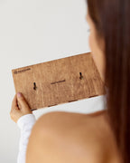 Person holding a wooden product with 'Bamboo' branding against a white background