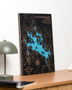 map design of Lake Winnipesaukee on a wooden surface.