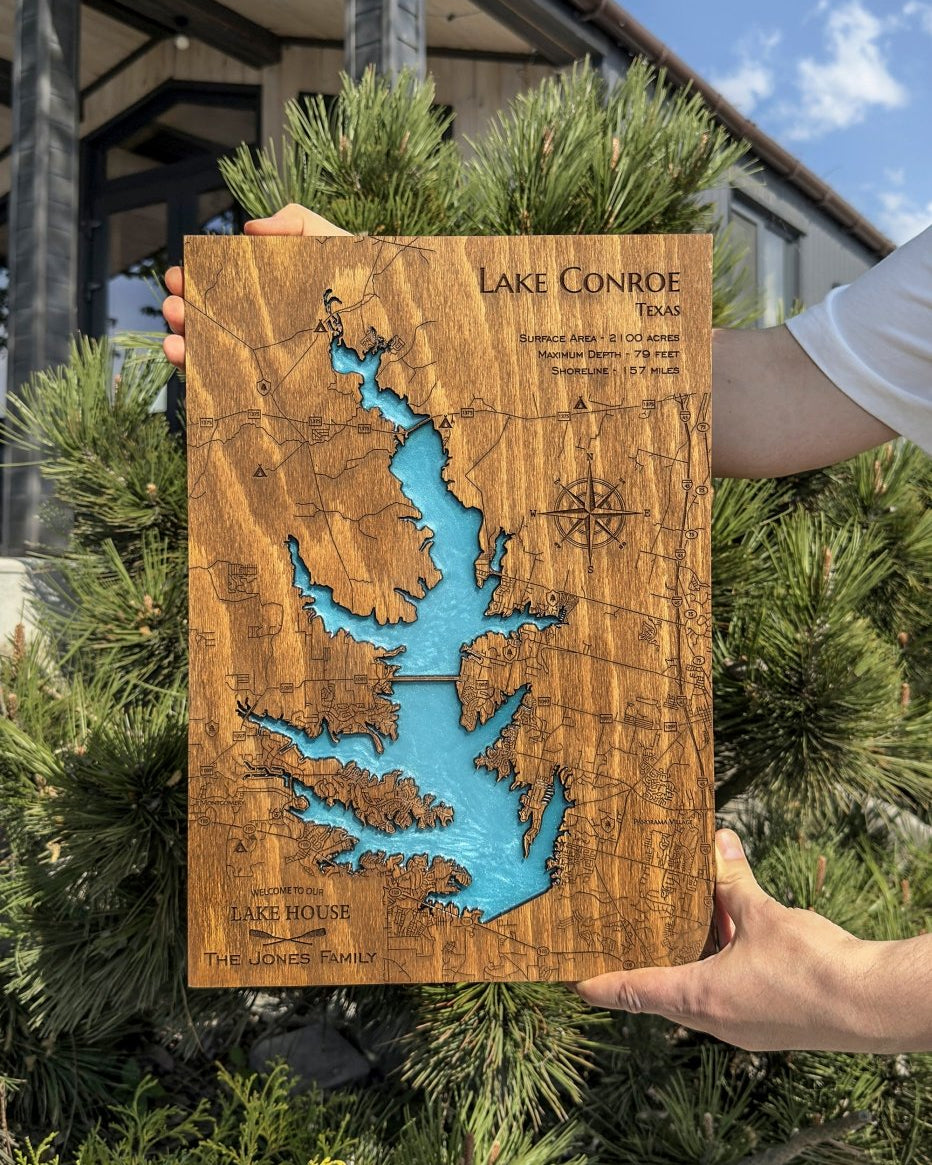 Wooden map of Lake Conroe, Texas held by a person outdoors.