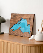 Wooden plaque with a map of Lake Superior on a wooden surface.