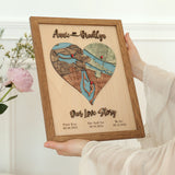 Woman holding a personalized three-location wooden heart map in an Early American oak frame.