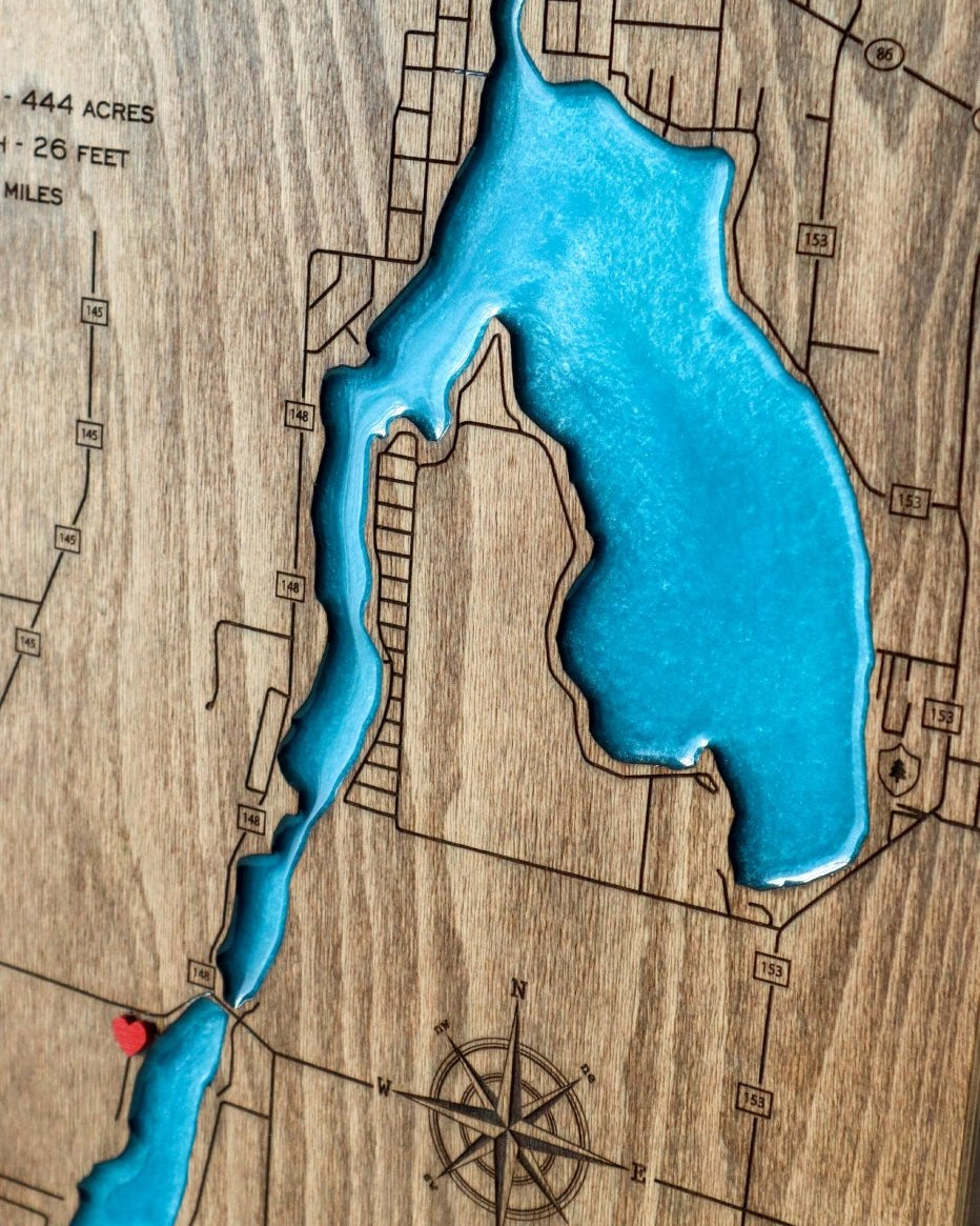 Wooden map with a blue lake inset and compass detail