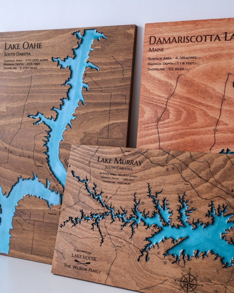 Wooden maps of Lake Oahe, Damariscotta Lake, and Lake Murray with embossed waterways.