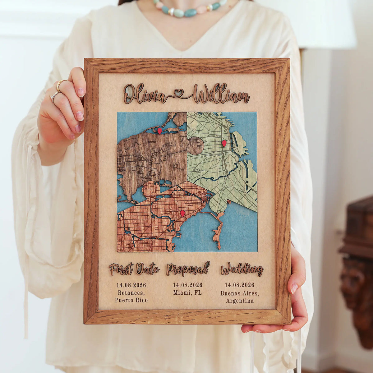Woman holding a Classic Square three-location wooden map in an Early American oak frame with personalized names and dates.