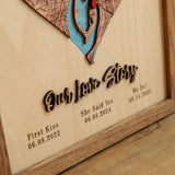 Close-up of raised Our Love Story lettering and personalized dates beneath a wooden heart map.