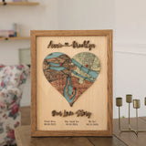 Personalized three-location wooden heart map with Our Love Story lettering displayed on a wooden table at home.