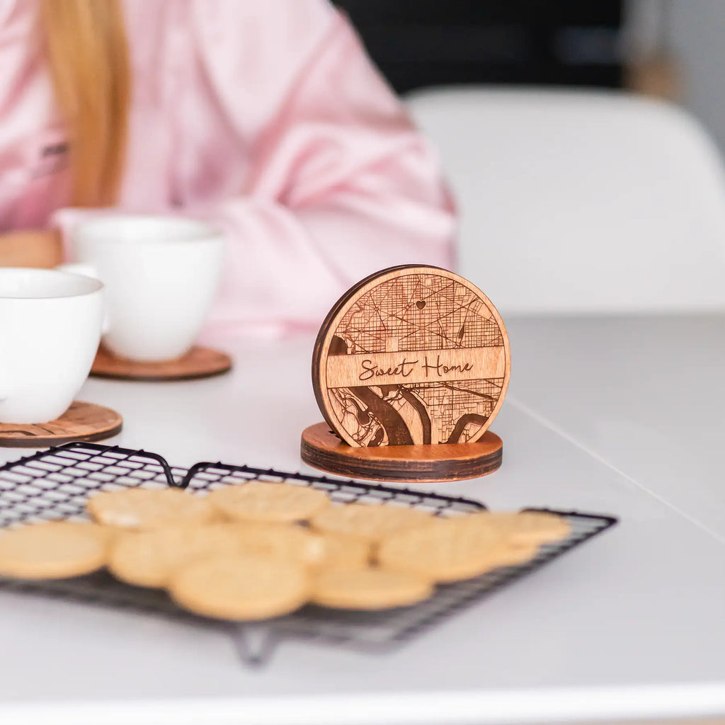 Close up of custom wooden coasters with engraved map design and matching holder personalized gift set