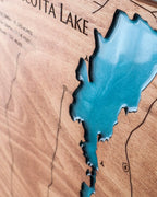 Wooden map of a lake with a blue inset showing water depth