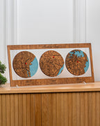 Wooden map display with three circular maps on a wooden shelf.
