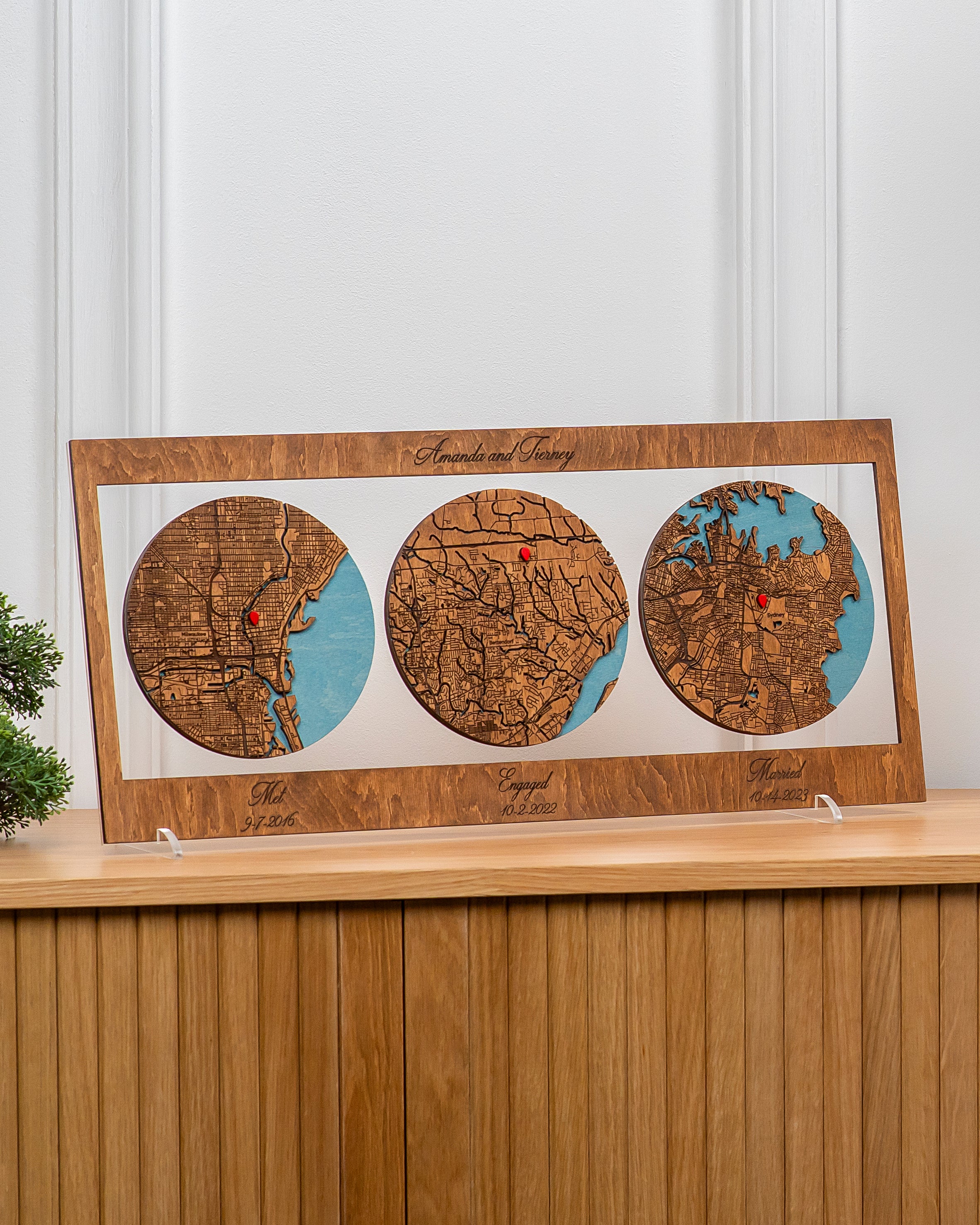 Wooden map display with three circular maps on a wooden shelf.