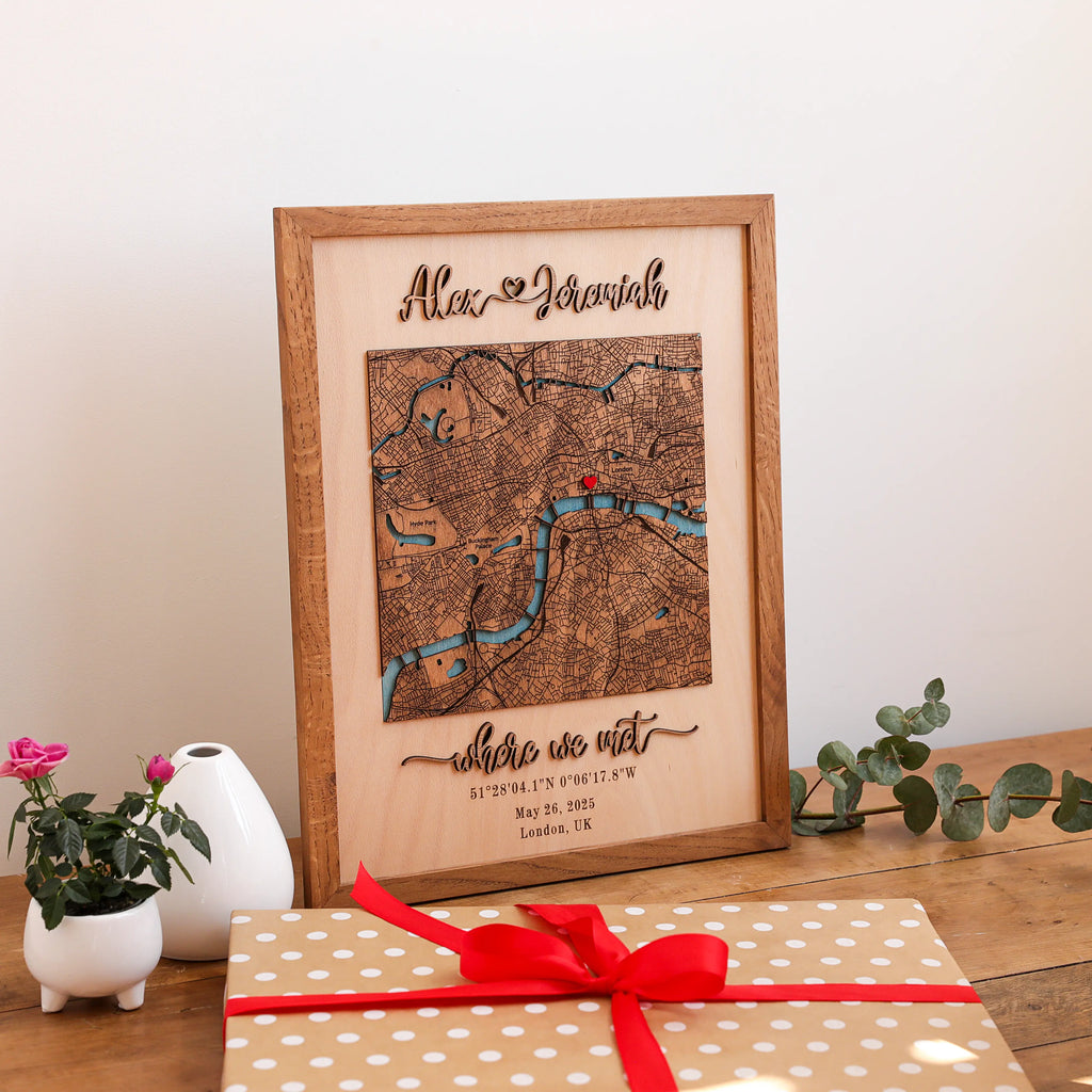 Gift-ready personalized wooden map displayed with wrapped gift packaging, custom names, London location, and Where We Met wording.