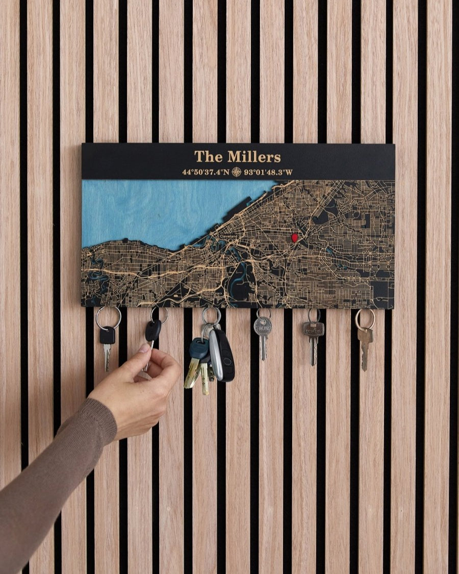 Key holder with personalized map design on a wooden wall.