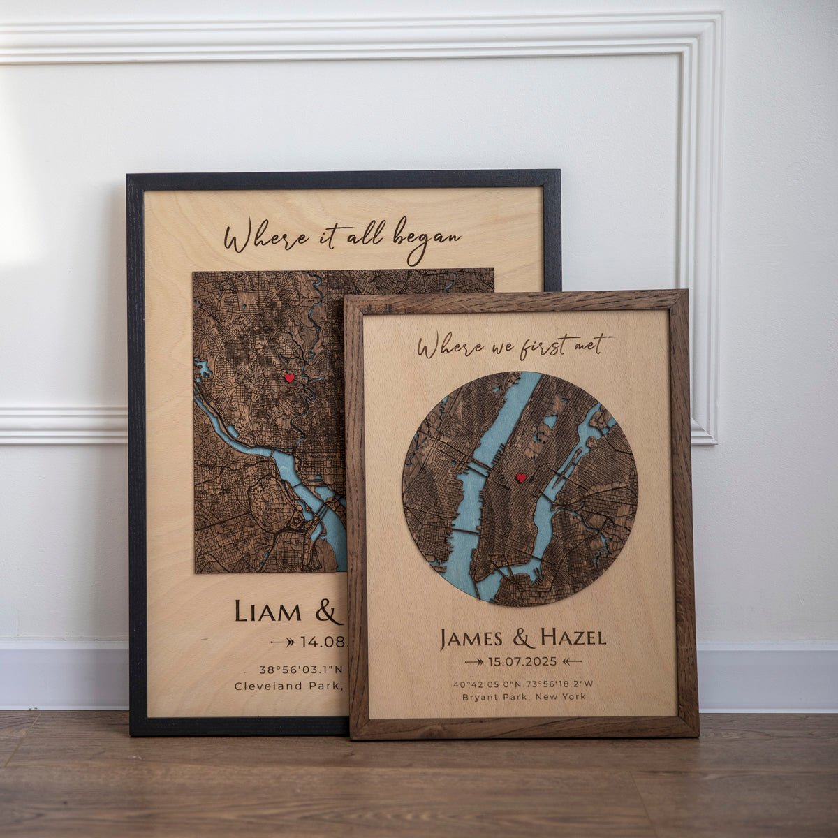 Two framed custom location maps with names and coordinates on wood floor