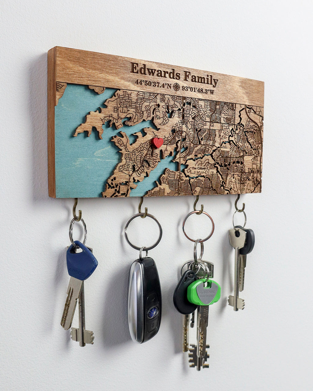 Key holder with engraved map design and custom text and coordinates on a white background