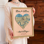 Woman holding a romantic personalized anniversary map for her with heart-shaped New Orleans location, raised 3D names, custom date, and sage oak frame.