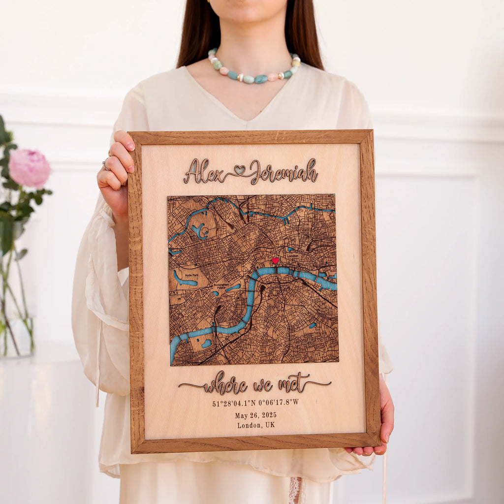 Woman holding a personalized wooden couple map with raised 3D names, custom London location, coordinates, date, and natural oak frame.