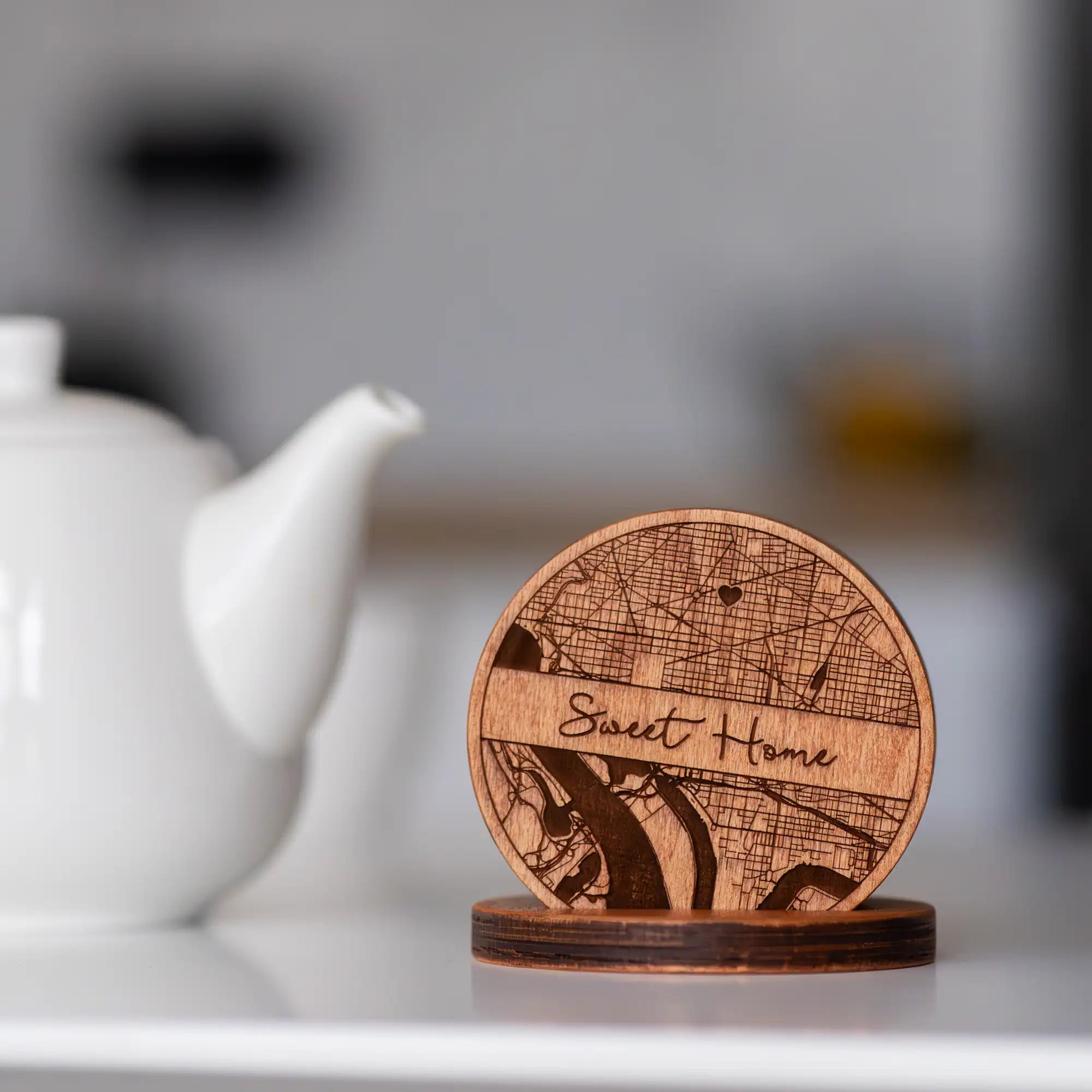 Personalized wooden coaster set with engraved map design and holder styled on a modern kitchen counter