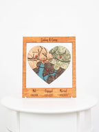 Customized heart-shaped map puzzle in a wooden frame commemorating the meeting, engagement, and marriage locations of a custom name with significant dates