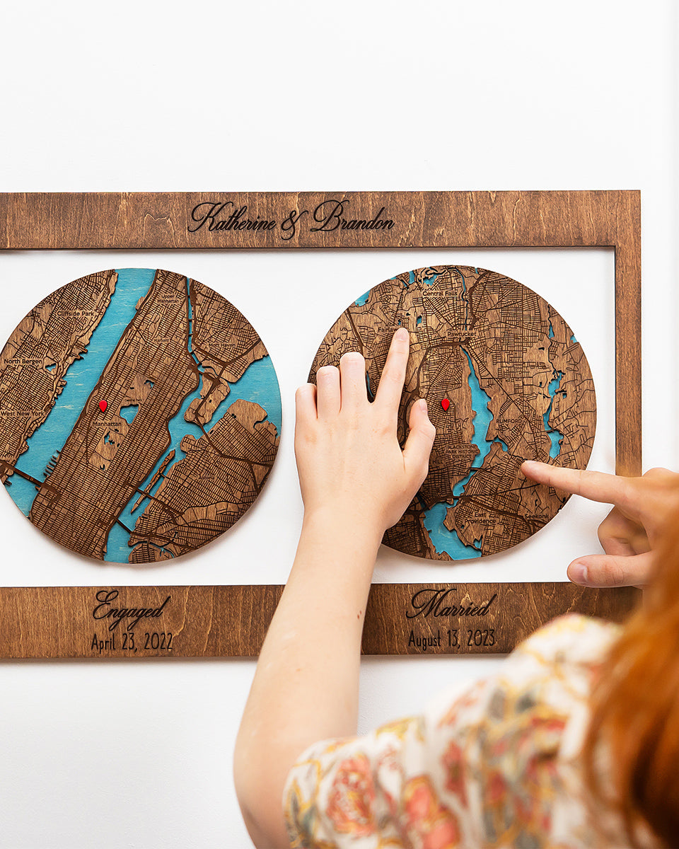 Wooden map location with engraved names and dates, held by a person.