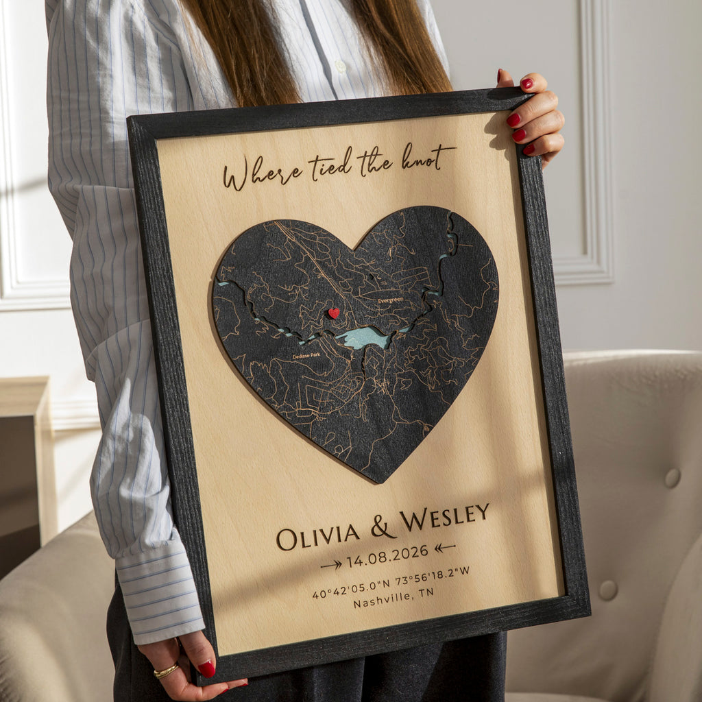 Woman holding personalized 3D wooden wedding wall art with heart map, names, date, and custom coordinates.