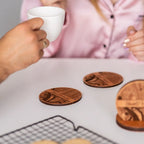 Engraved wooden coaster set with holder used on table with coffee cups as a personalized gift set