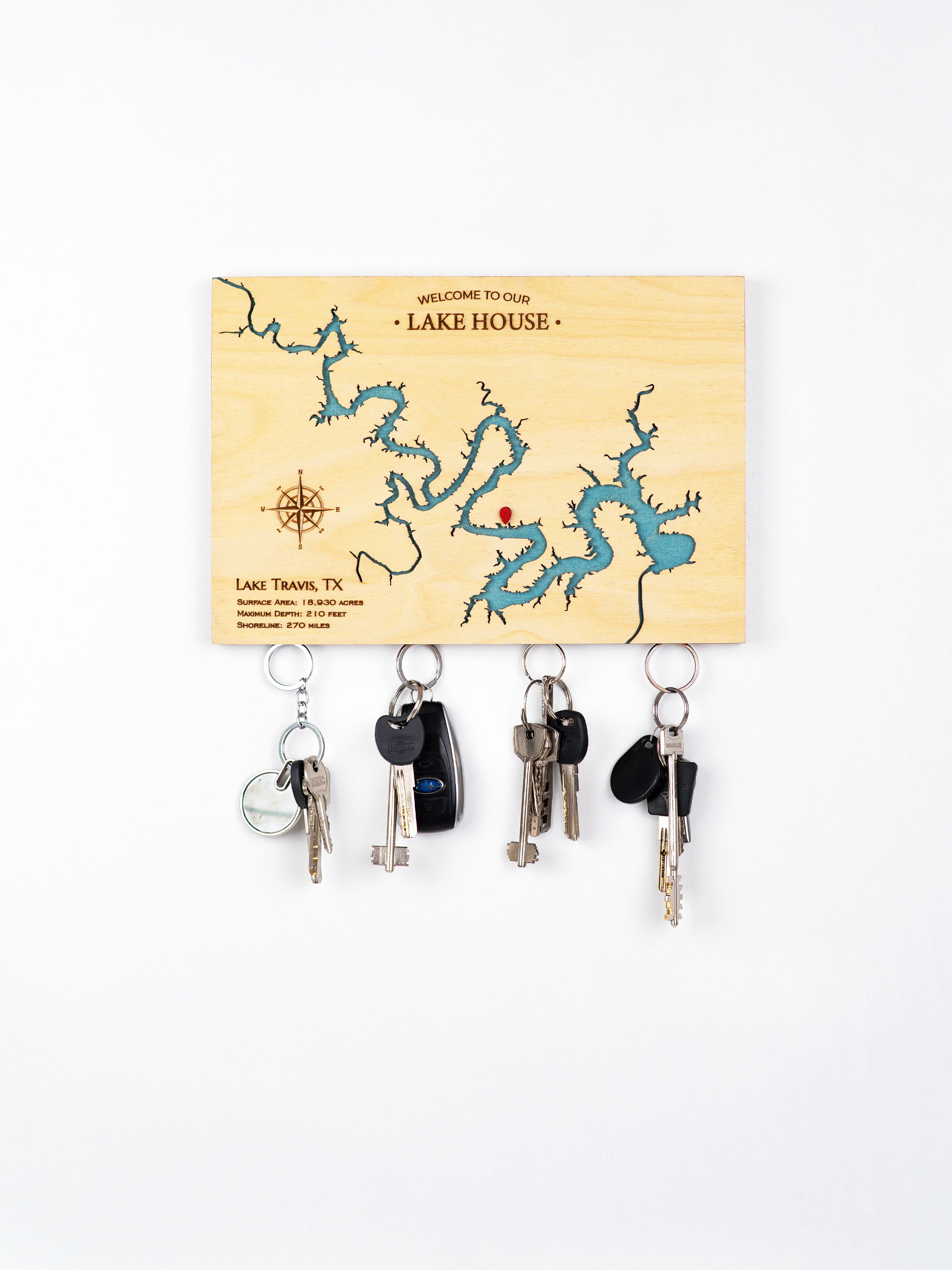 Wooden key ring with a carved and colored image of Lake Travis, Texas, mounted on the wall with a  magnetic holder