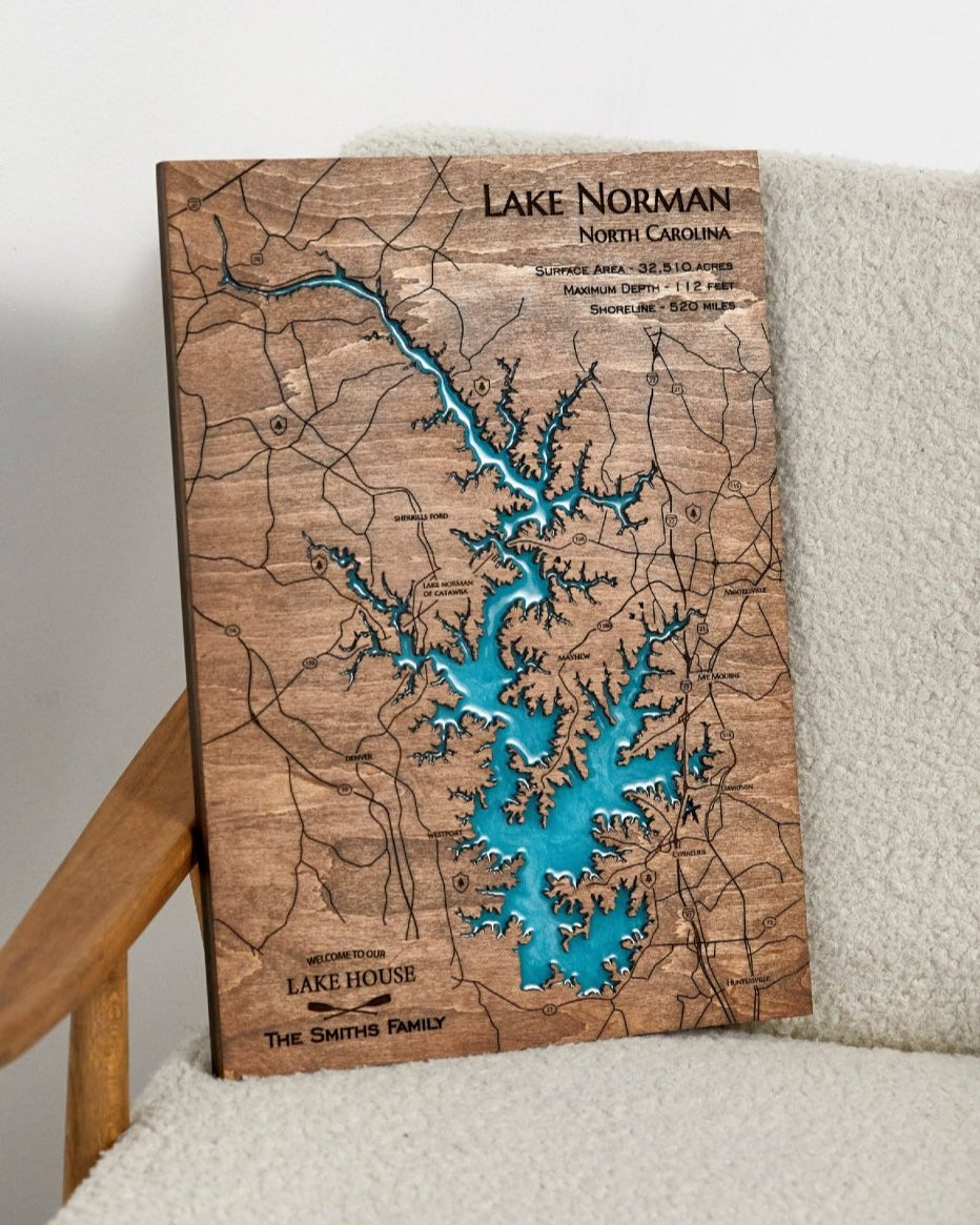 Wooden map of Lake Norman, North Carolina, with blue water inset, on a white surface.