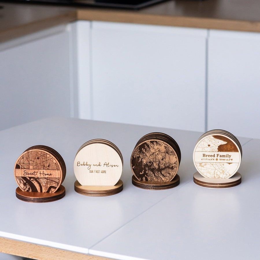 Four wooden coasters with circular designs on a kitchen counter.