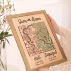 Custom engaged map held in hands, showing two personalized locations, raised wooden text, and sage oak frame.